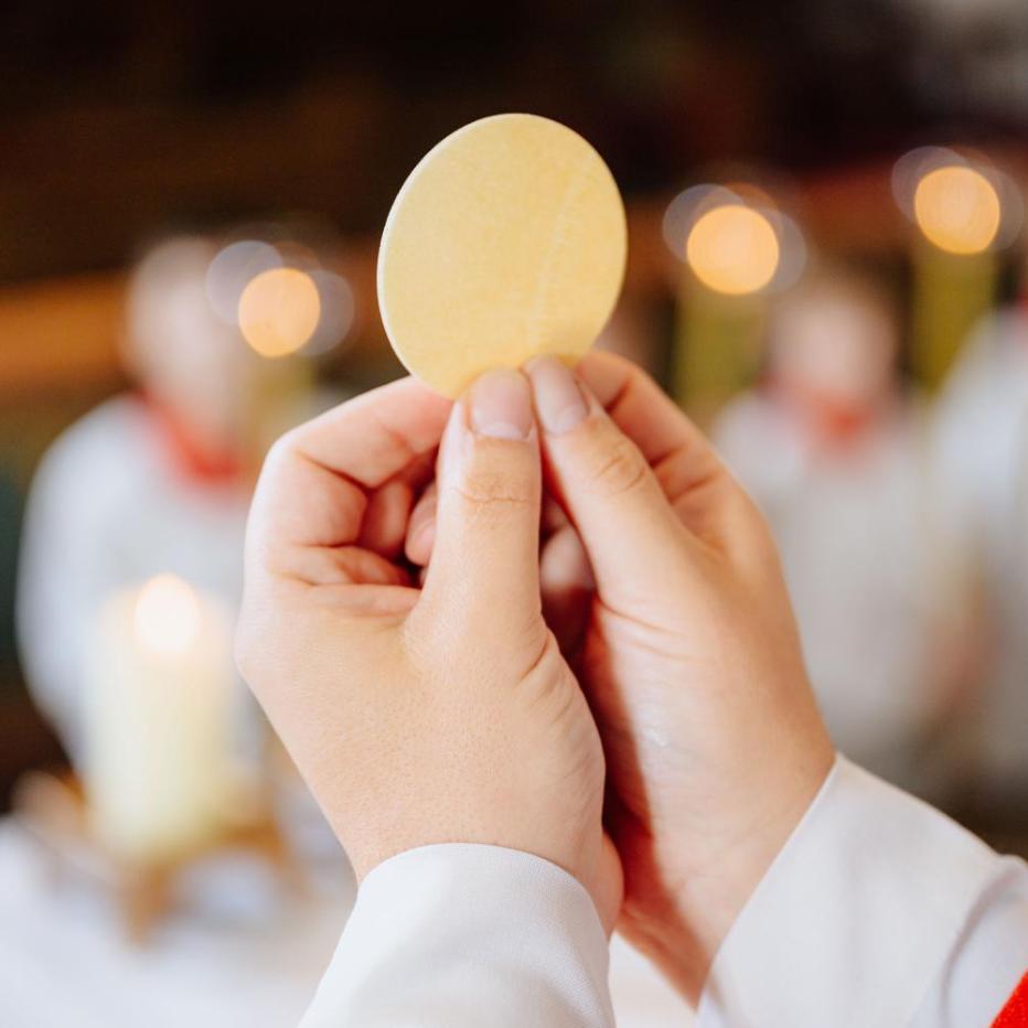 Priester zeigt der Gemeinde die Hostie bei der Eucharistiefeier