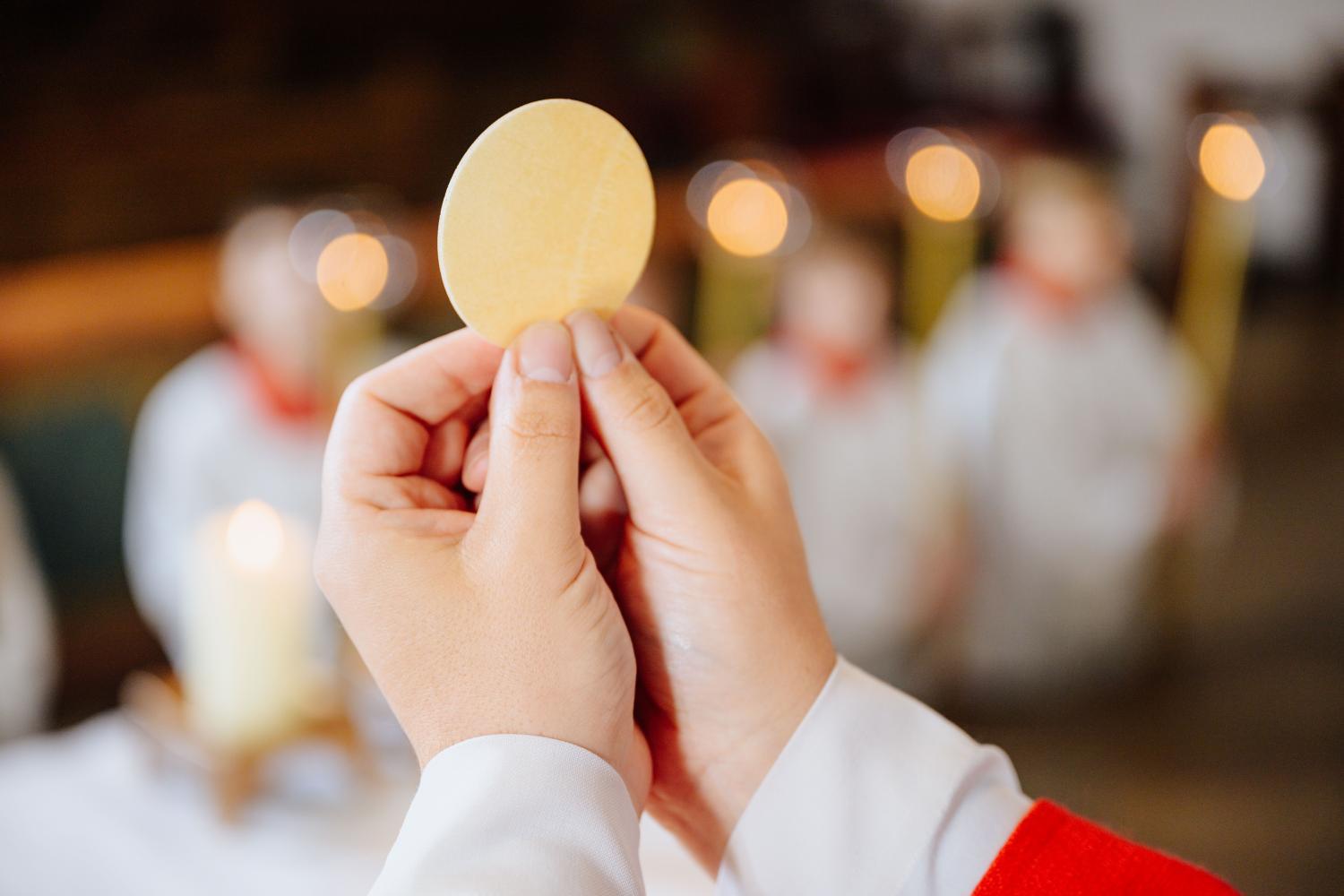 Priester zeigt der Gemeinde die Hostie bei der Eucharistiefeier