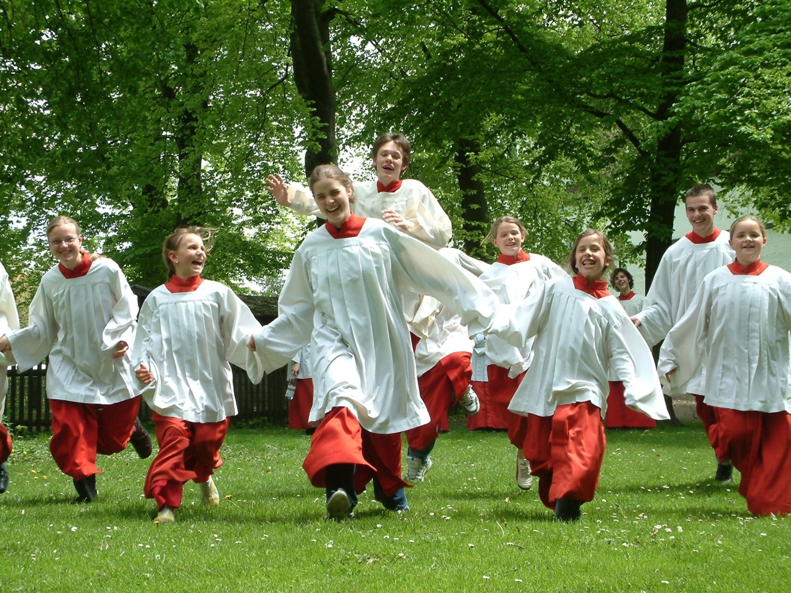 eine Gruppe Messdiener läuft über eine Wiese